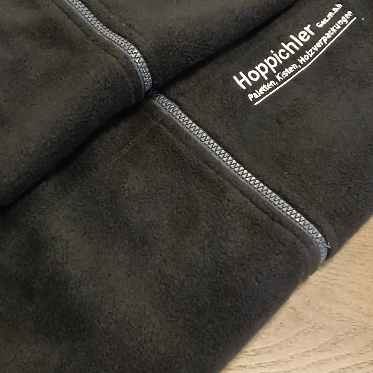 Schwarze Fleecejacke mit weißem Stick für Hoppichler Ges.m.b.H.
